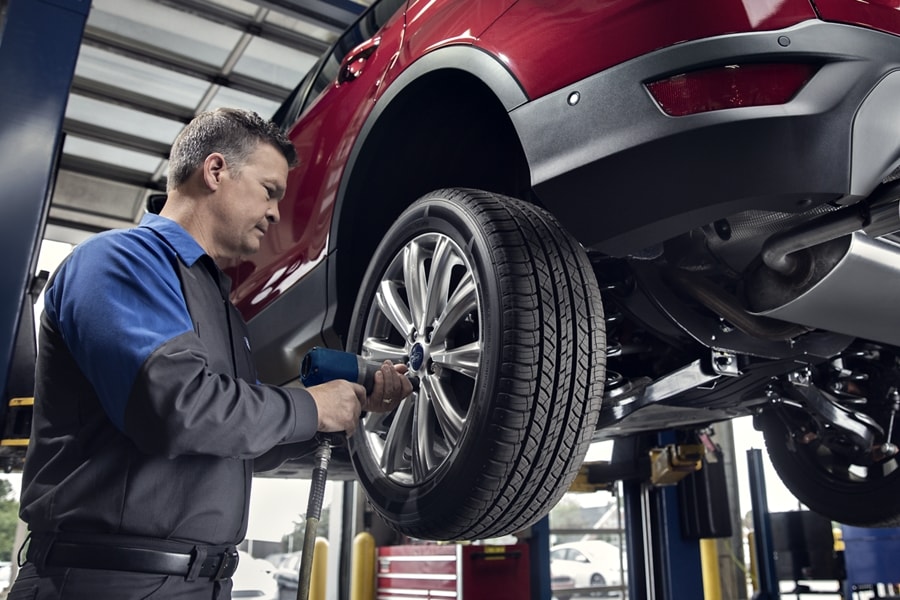 Ford Dealer Technician changing a tire at the dealership