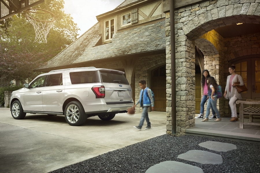 Family walking out to a Ford Expedition parked in their driveway