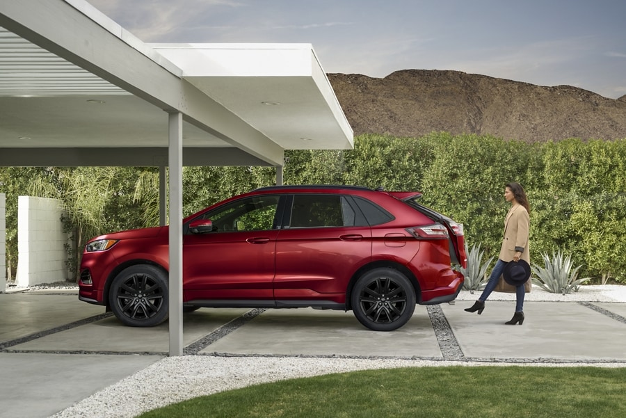 Woman carrying two bags activates the hands-free liftgate on a 2023 Ford Edge