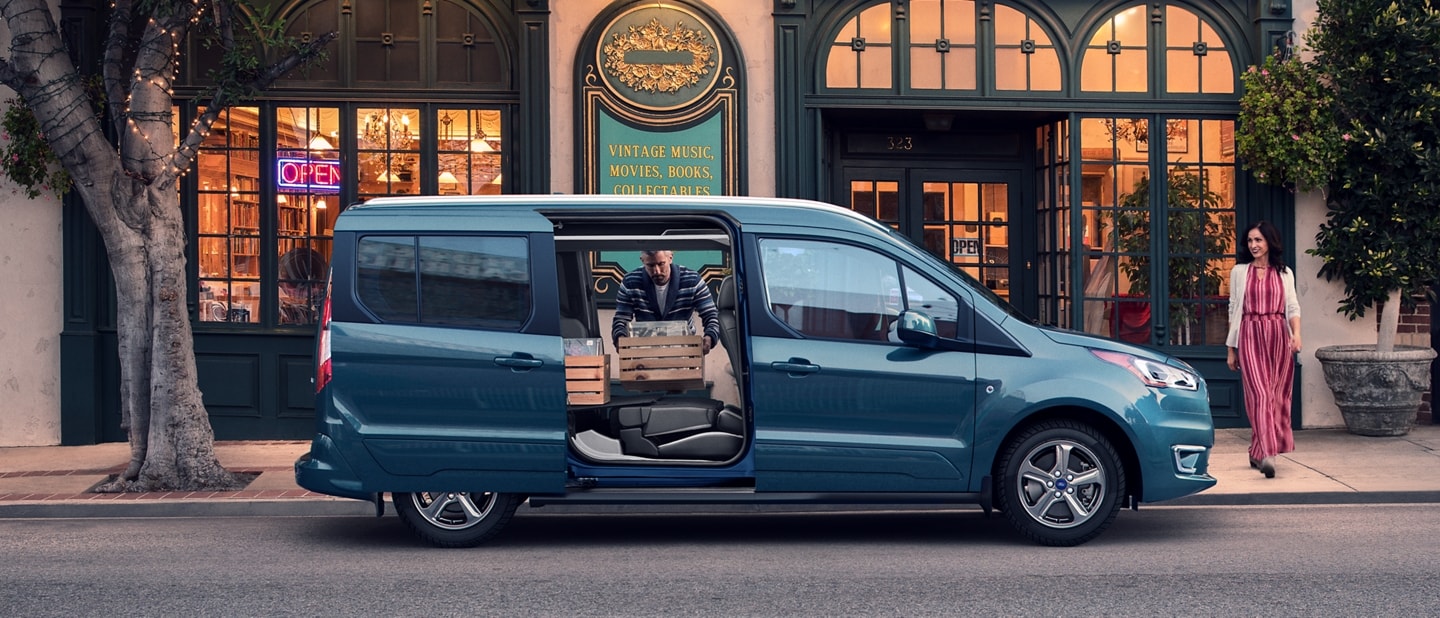 2023 Ford Transit Connect Passenger Wagon parked on city street with opened dual sliding side doors