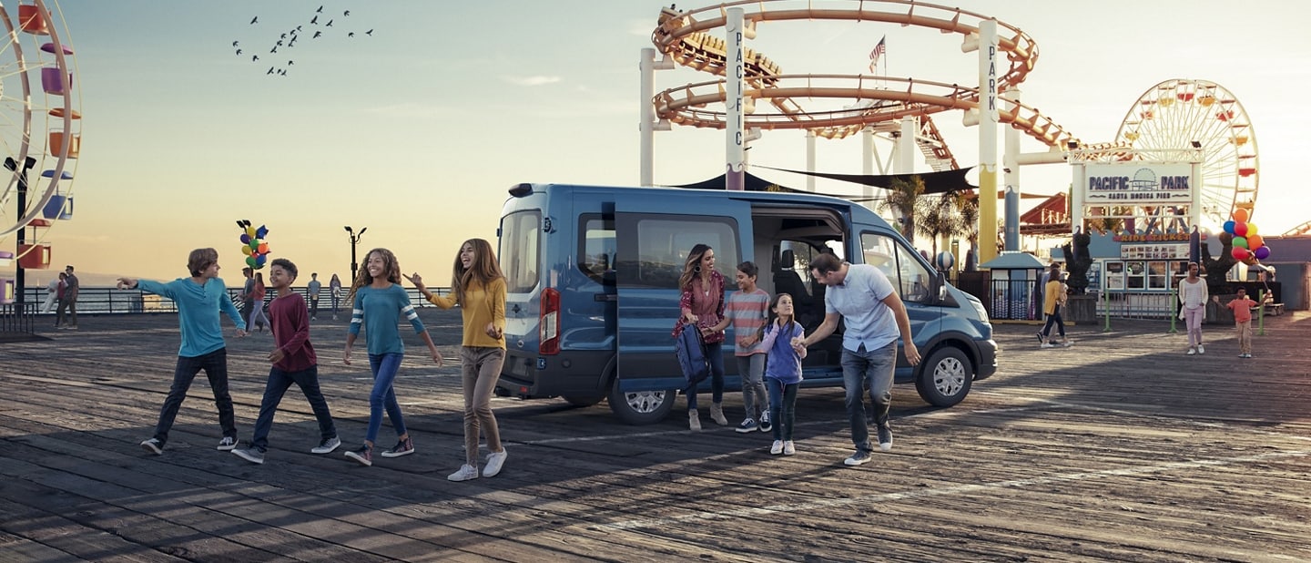 A family exiting a 2022 Ford Transit® van at a carnival