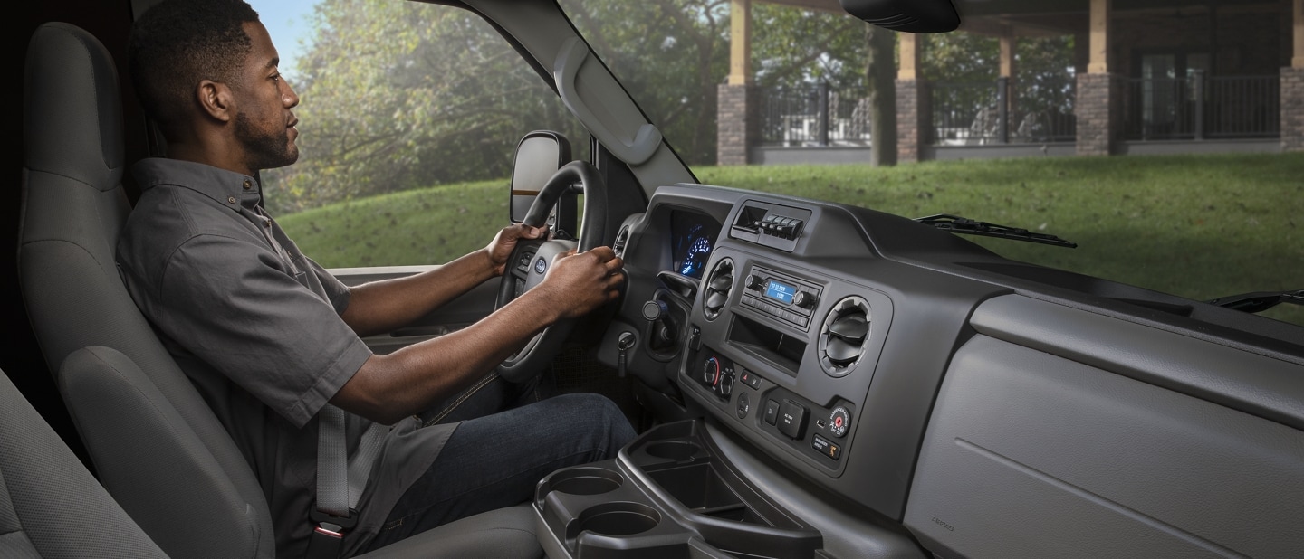 A man in the drivers seat of a 2024 Ford E-Series