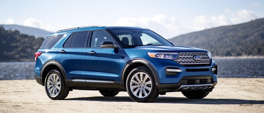 2023 Ford Explorer® Limited Hybrid SUV parked on a beach near a lake
