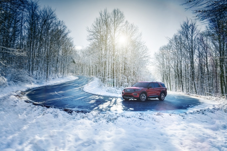 2022 Ford Explorer in Rapid Red being driven on a snowy road