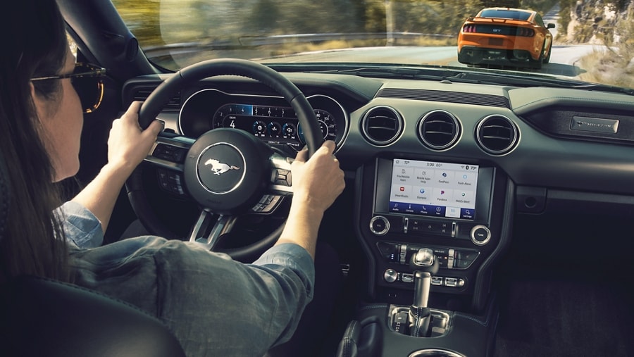 Driver using available SYNC® AppLink® in a 2021 Ford Mustang