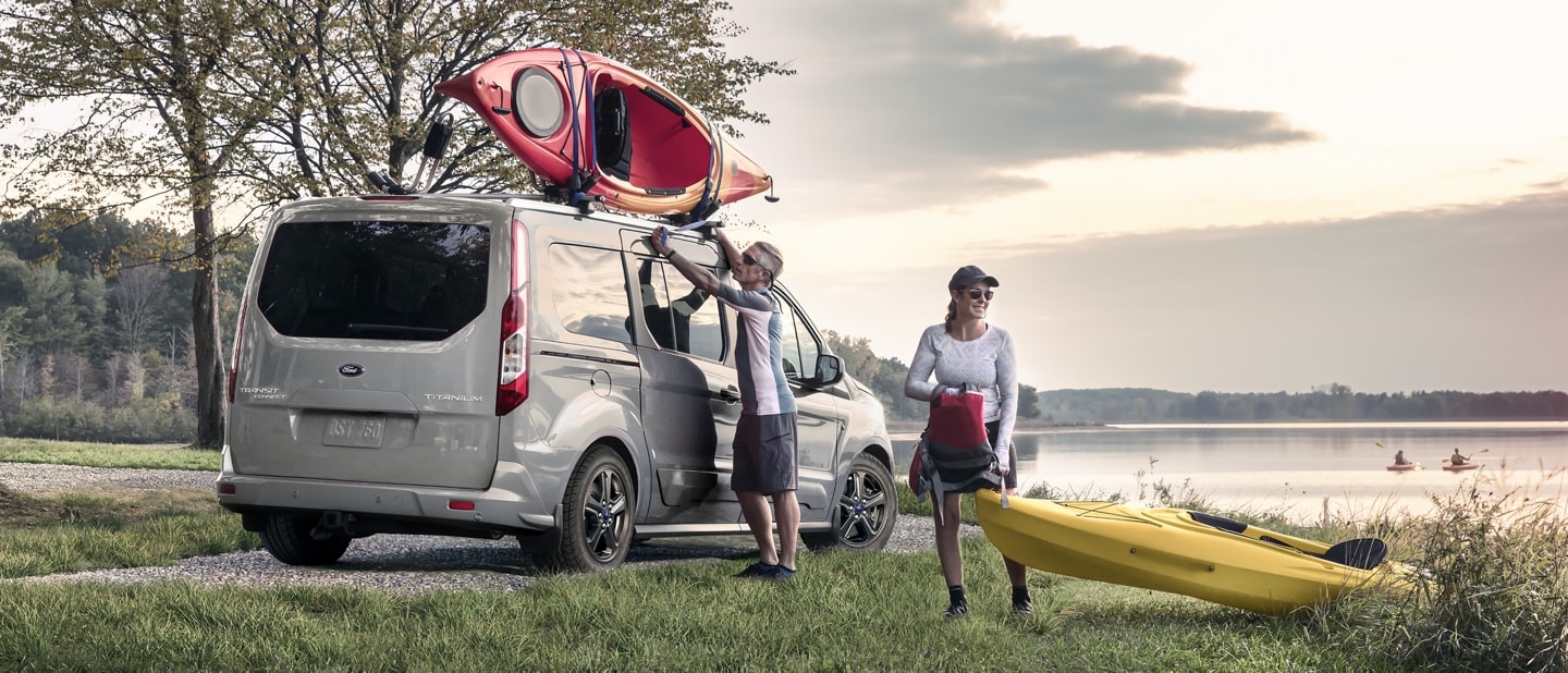 2023 Ford Transit Connect Passenger Wagon in Solar Silver by a lake with two kayakers