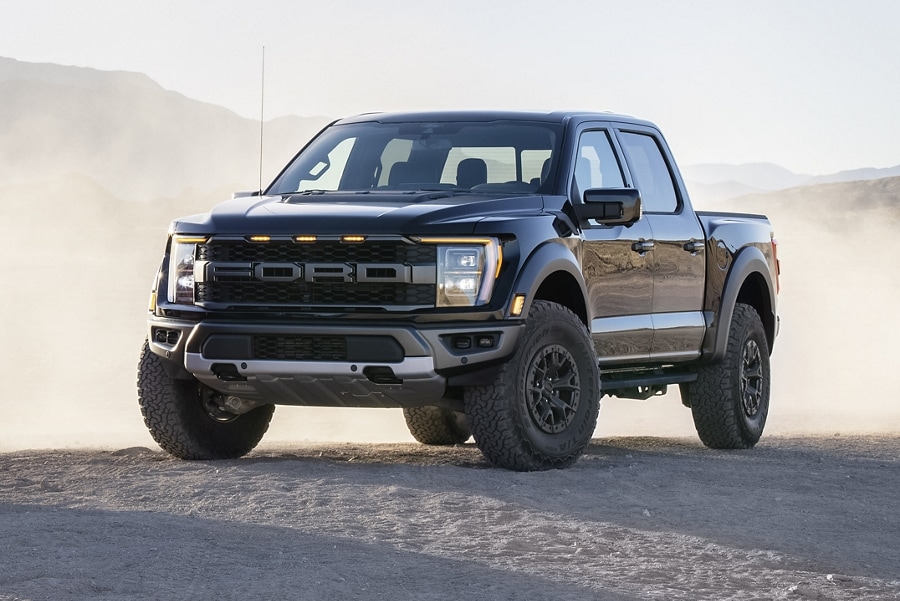 2022 F-150® Raptor® in Agate Black parked in the desert with dust blowing