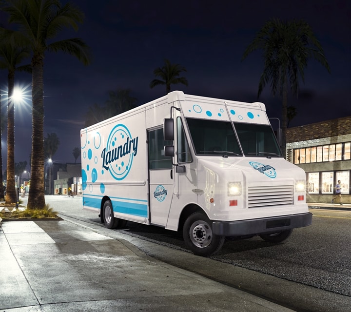 Commercial laundry service vehicle being driven at night