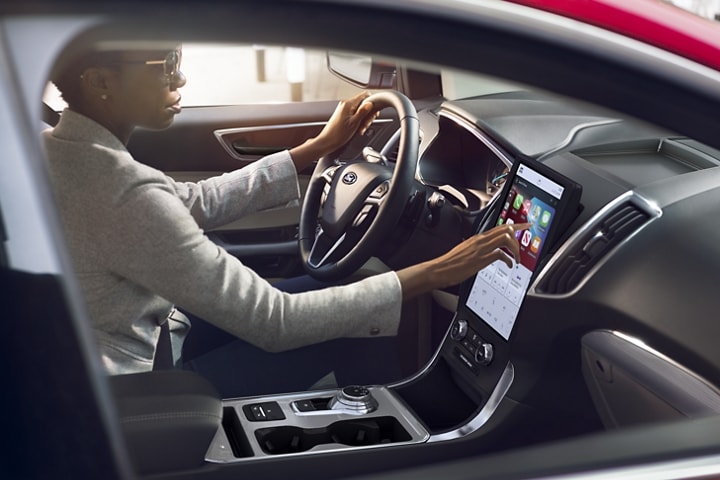 Woman using the touchscreen in a 2023 Ford Edge® SUV