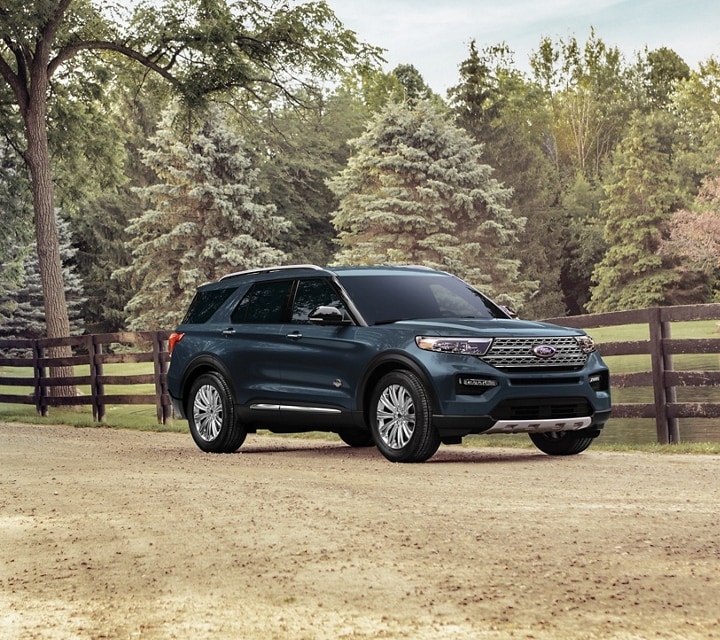 2023 Ford Explorer® King Ranch® SUV in Stone Blue Metallic extra cost color option parked next to a fenced pond