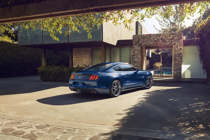 2023 Ford Mustang® coupe parked in front of a stylish contemporary home
