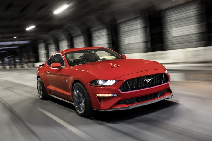 A 2023 Ford Mustang® coupe in Race Red being driven through a tunnel