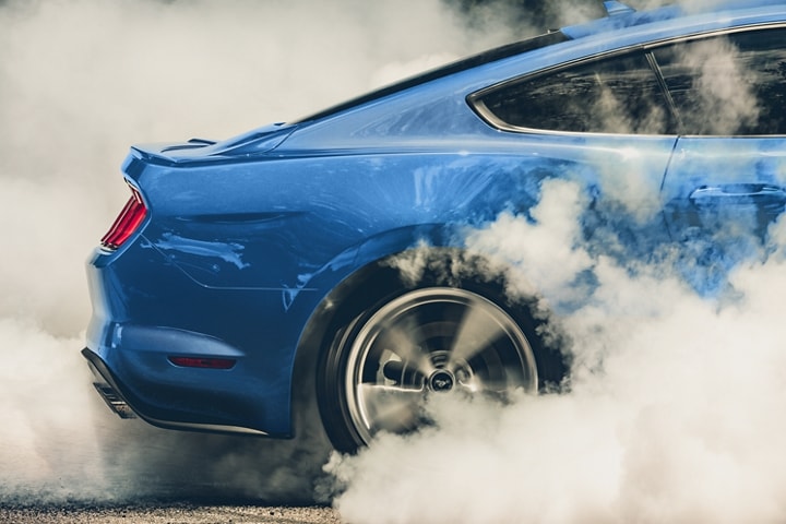 Close-up of a 2023 Ford Mustang® coupe performing a burnout