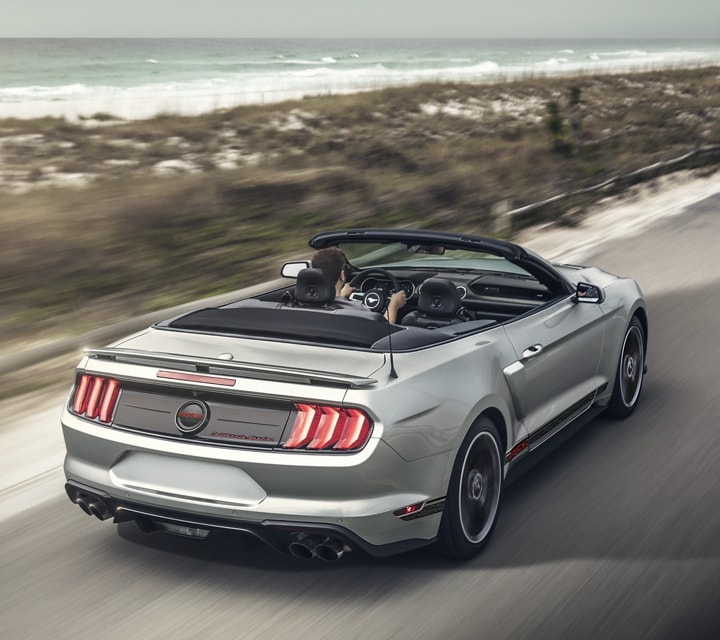 A 2023 Ford Mustang® convertible with the California Special Package traveling down a beachside highway