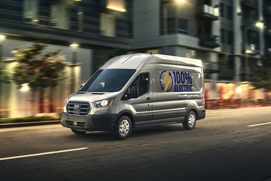 A 2023 Ford E-Transit® van being driven in an urban environment