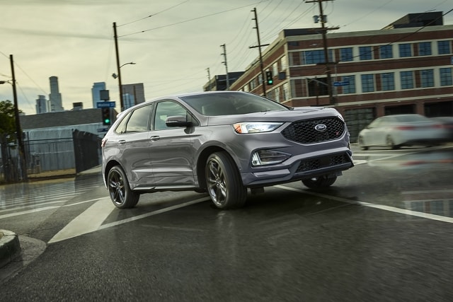 2023 Ford Edge® SUV in Iconic Silver being driven on a wet city street