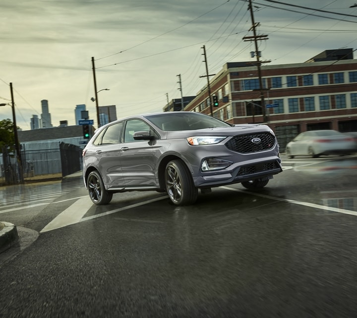 2023 Ford Edge® in Iconic Silver turning on a curved urban road