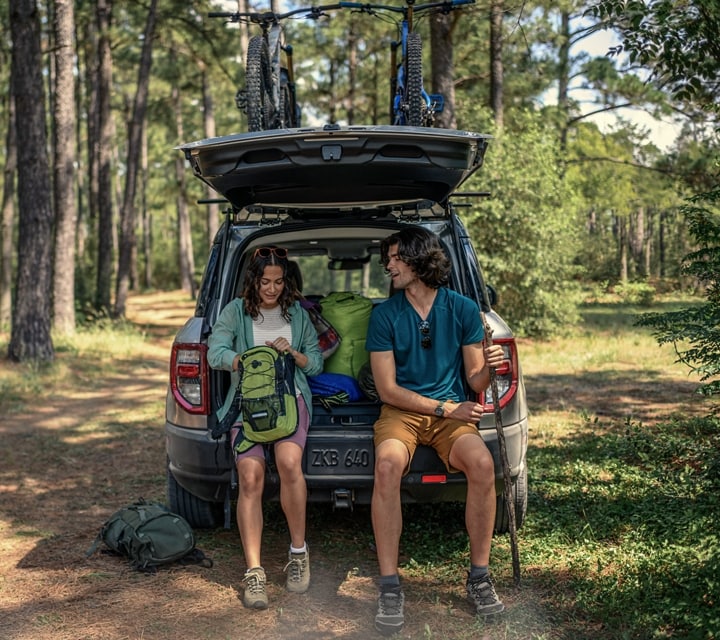 A woman and a man sitting in the back cargo area of a 2024 Ford Bronco® Sport