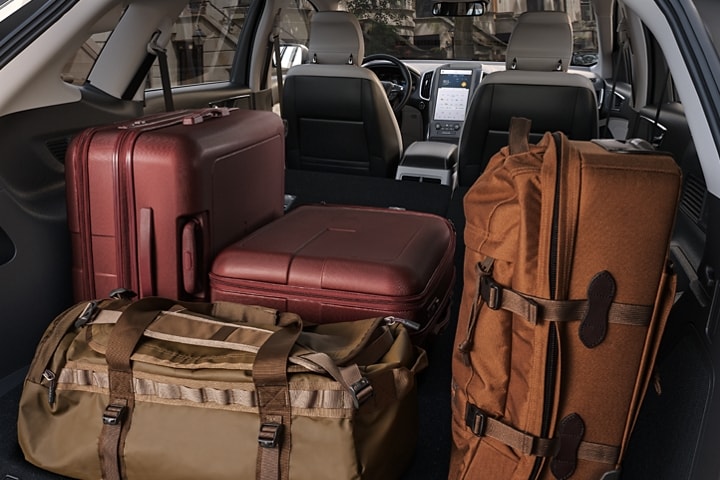 Interior of back of 2023 Ford Edge® SUV loaded with suitcases and baggage