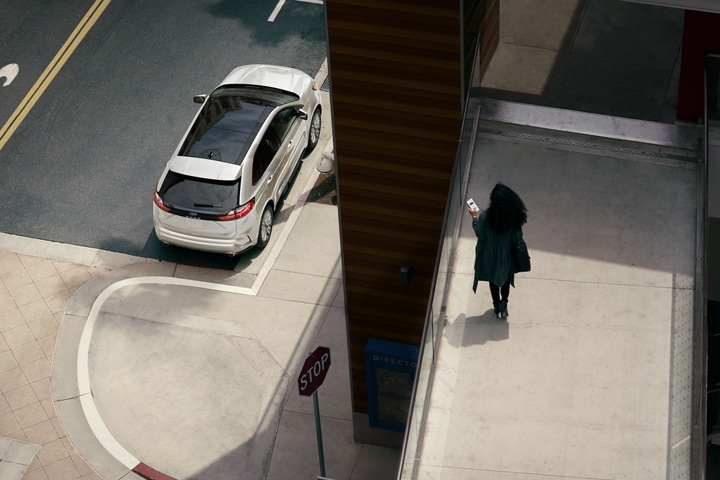Woman on a walkway overlooking her 2023 Ford Edge® SUV parked on the street below