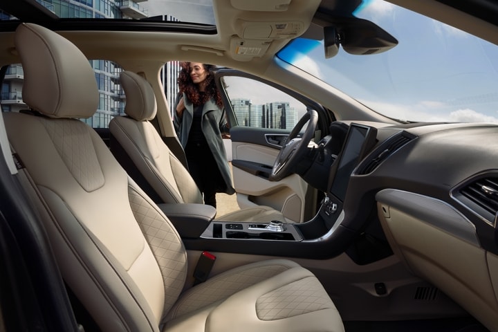 Interior of 2023 Ford Edge® Titanium model with a woman closing the driver side door