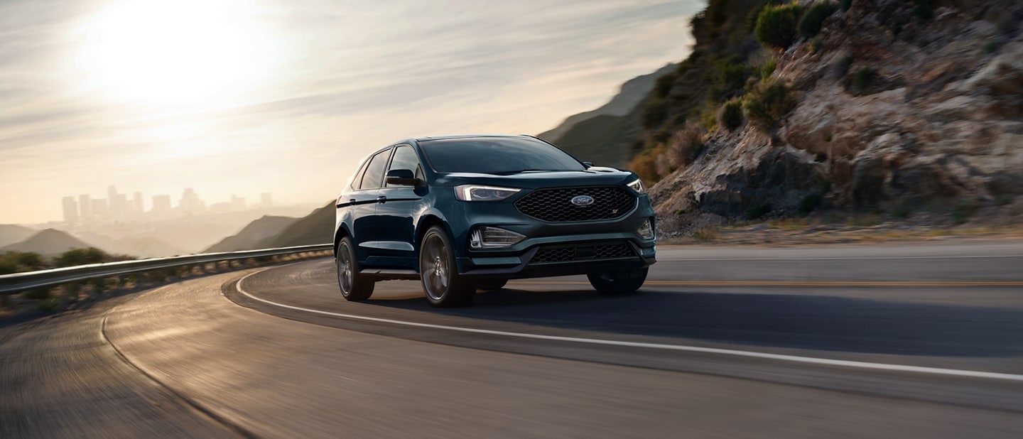 2024 Ford Edge® ST in Stone Blue being driven on a mountain curve