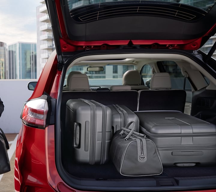 A woman beside a 2024 Ford Edge® with back hatch open full of luggage