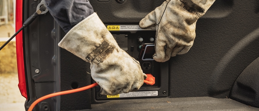 Close-up of a worker plugging an electrical cord into the Pro Power Onboard feature