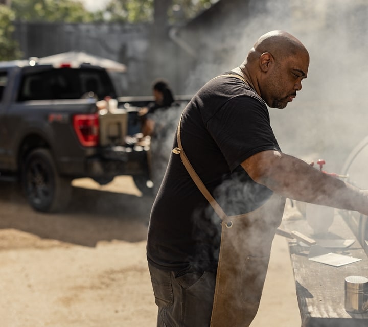 Man grilling near a 2023 Ford F-150® pickup