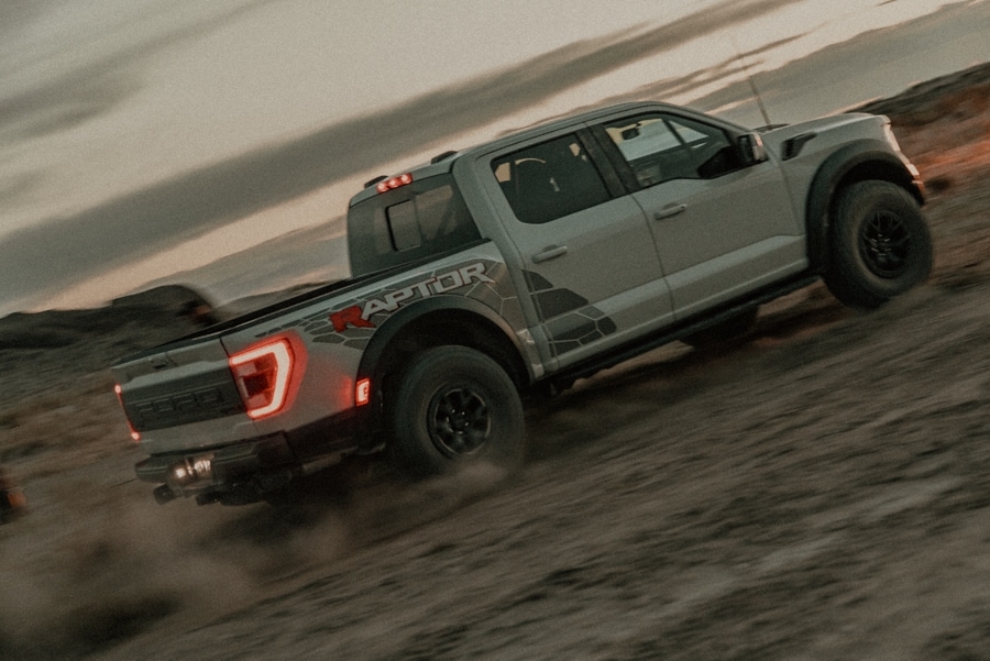 2023 Ford F-150® Raptor R™ being driven in the desert at dusk kicking up dust