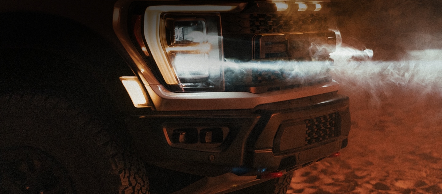 Close-up on the headlamps of the 2023 Ford F-150® Raptor R™ with dust blowing