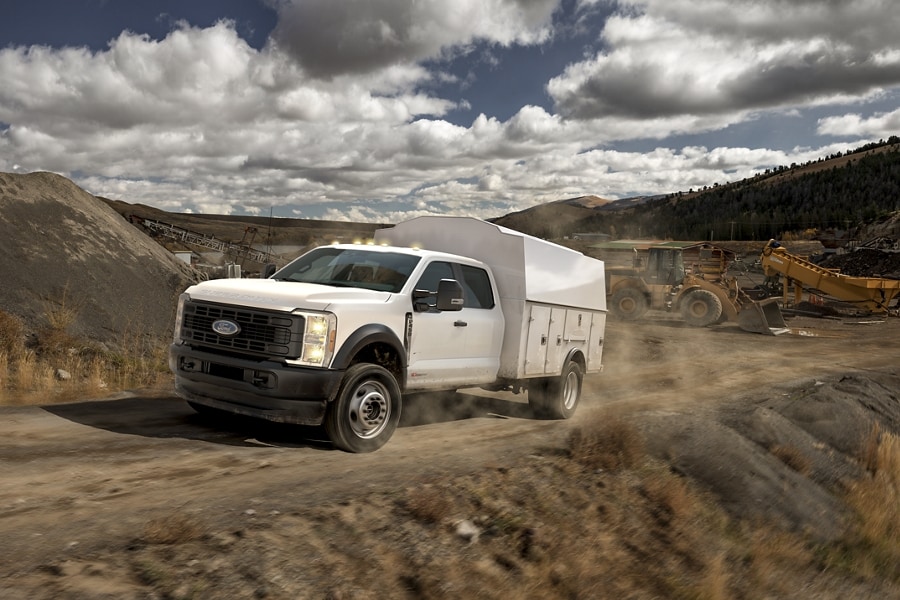 2023 Ford Super Duty® Chassis Cab being driven on a dirt road with an upfit