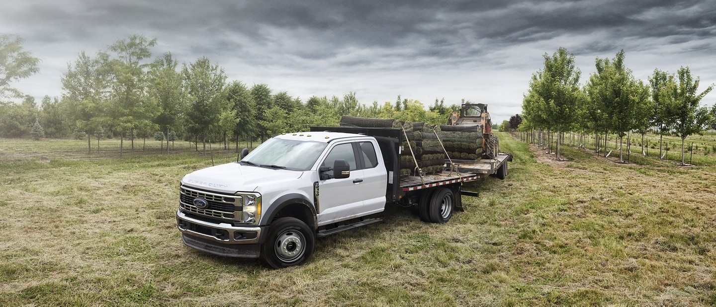 2023 Ford Super Duty® Chassis Cab with a flatbed upfit parked in an orchard