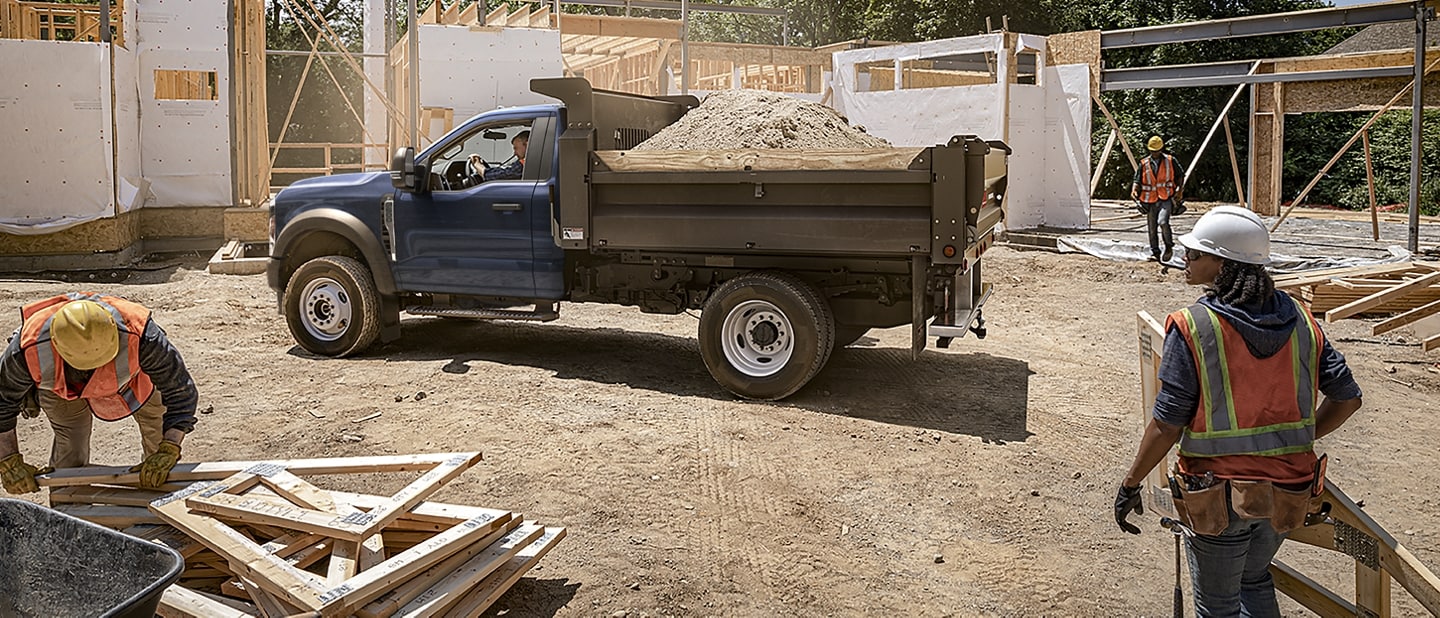 2023 Ford Super Duty® F-600® Chassis Cab XLT in Antimatter Blue with dump body upfit on a job site