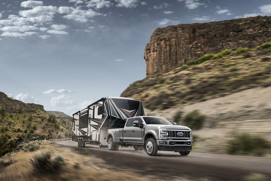 2023 Ford Super Duty® F-450® Limited model pulling a camper trailer on a mountain roadway