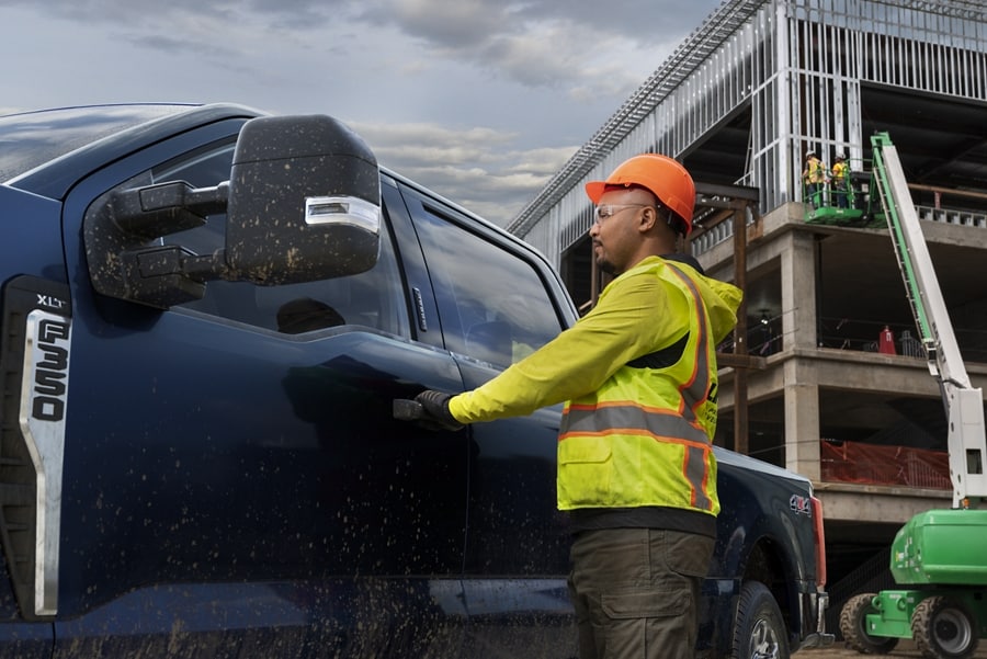 Construction worker opening the door of a 2023 Ford Super Duty® F-350® with XLT