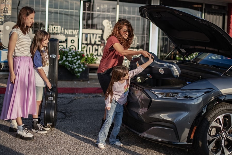 A woman and little girl unloading the frunk of a 2023 Ford Mustang Mach-E®