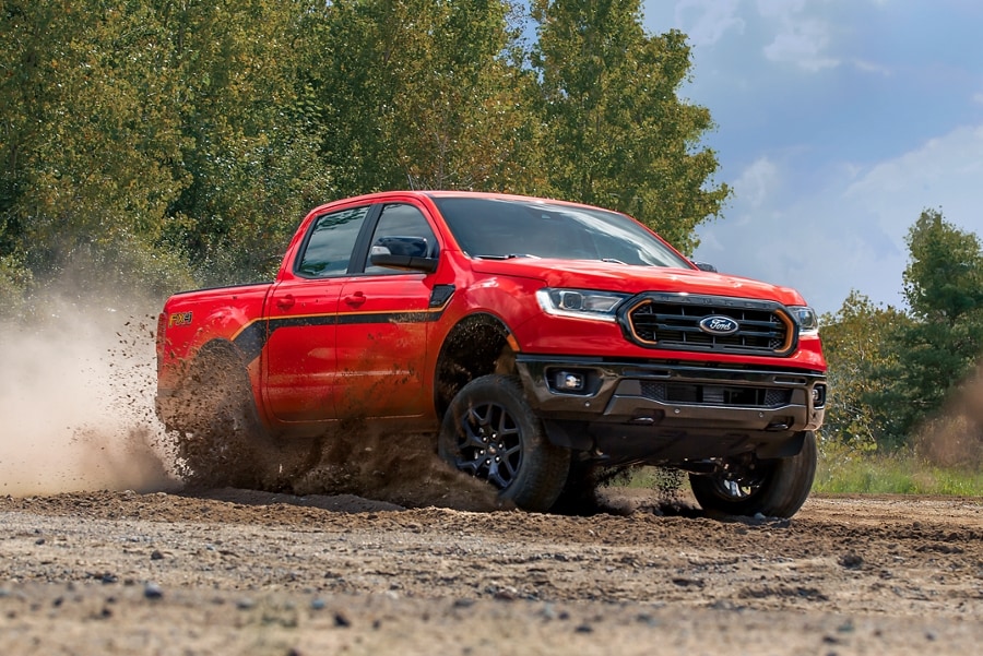 2023 US Ford Ranger in Race Red with the Splash Package driving through mud