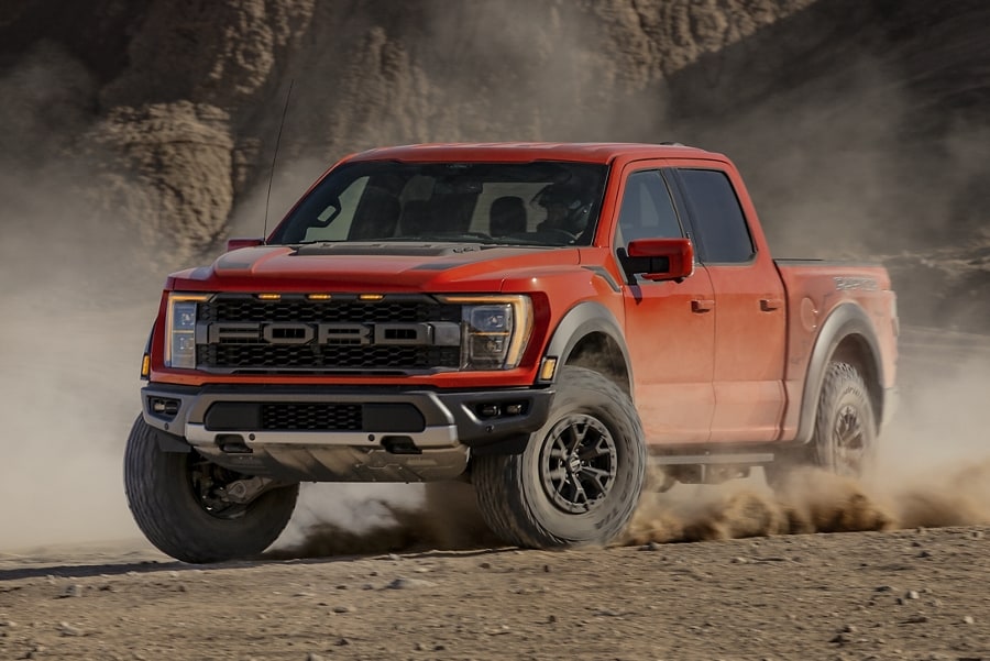 2023 Ford F-150® Raptor being driven in the desert kicking up sand