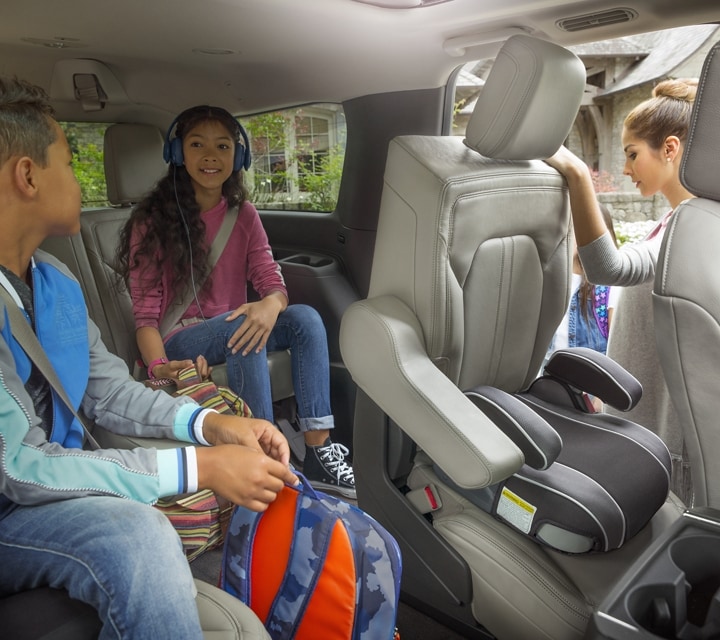 A 2024 Ford Expedition SUV with two children sitting in the rear seats as mom pulls second row seat forward