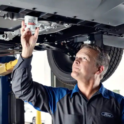 A Ford Service Technician replacing an oil filter.