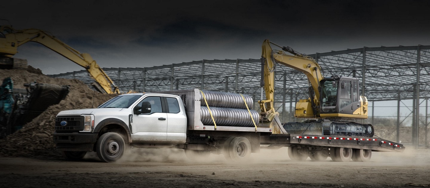 2023 Ford Super Duty® F-600® XLT Chassis Cab in Oxford White with bucket upfit parked at a construction site