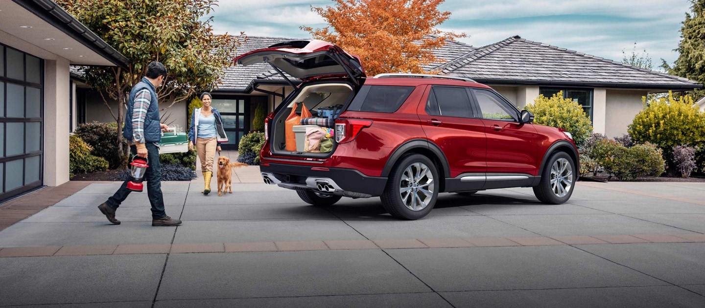 People put camping gear in the cargo area of a 2023 Ford Explorer parked in their driveway