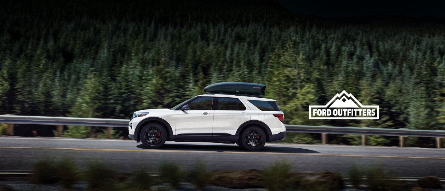 2022 Ford Explorer in Oxford White being driven along a wooded highway