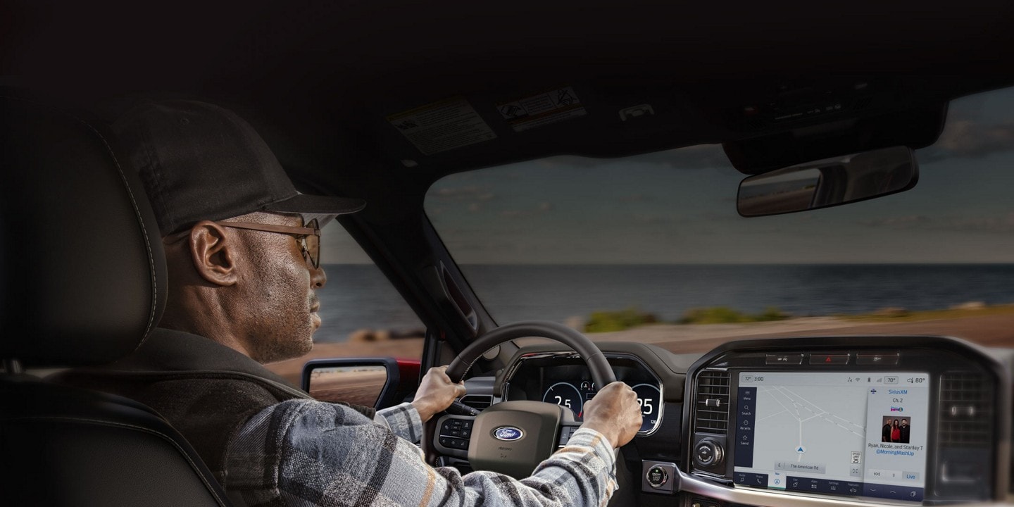 Man driving a 2023 Ford F-150® pickup viewing the 12-inch display screen