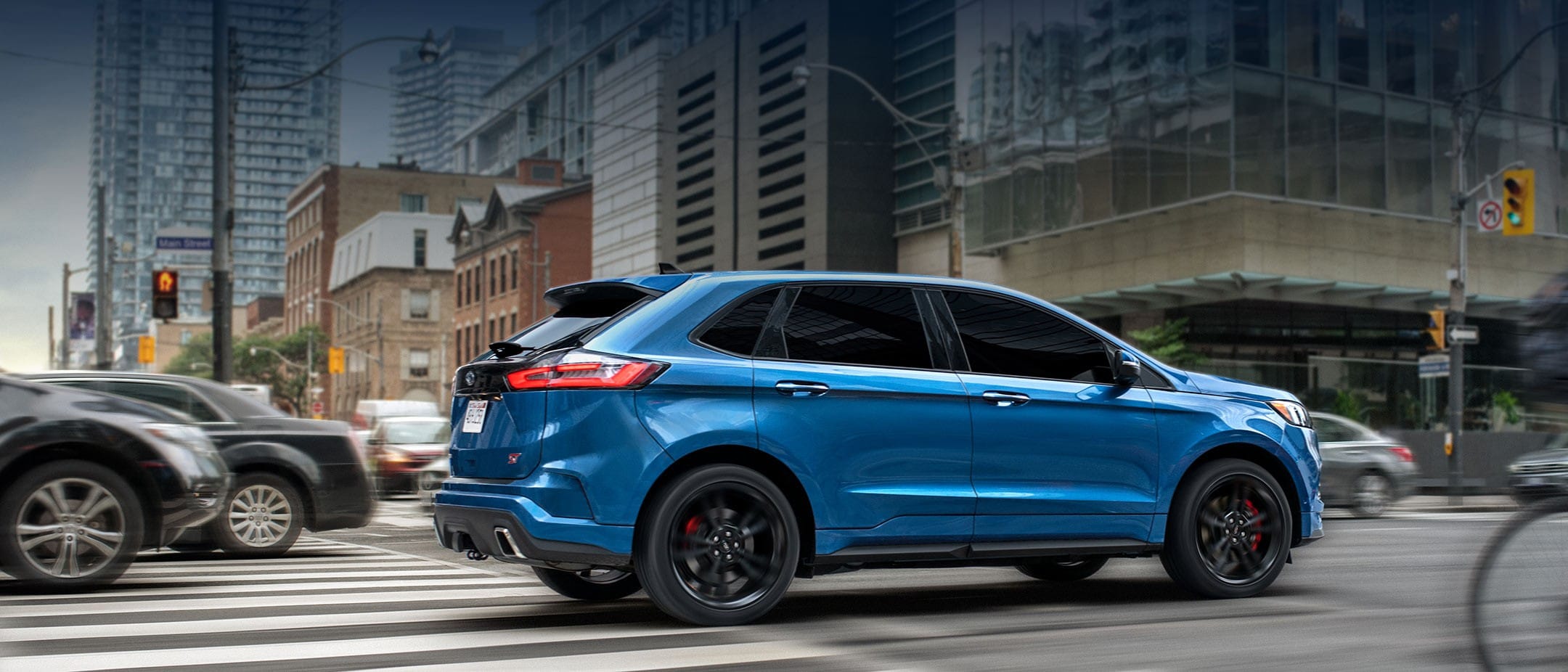 The 2019 Ford Edge ST in Ford Performance Blue driving on a city street.