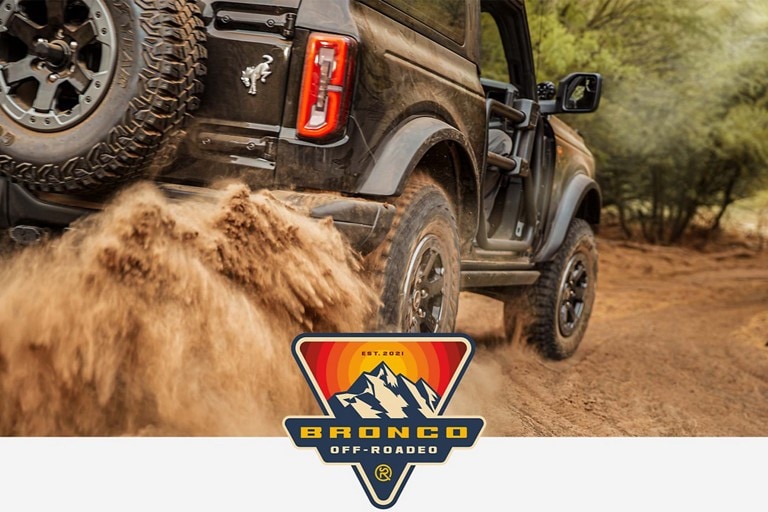 Ford Bronco® Off-Roadeo Logo with a 2023 Ford Bronco® model being driven over a rough trail