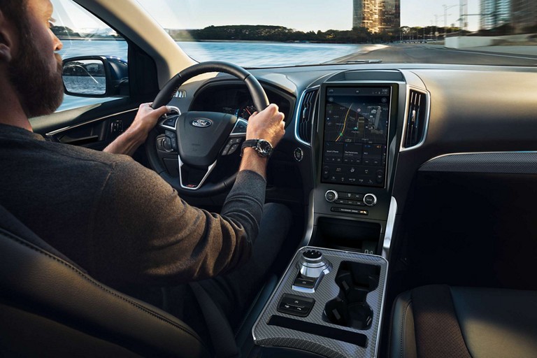 Close-up of a man driving a 2023 Ford Edge® with hands on the heated steering wheel