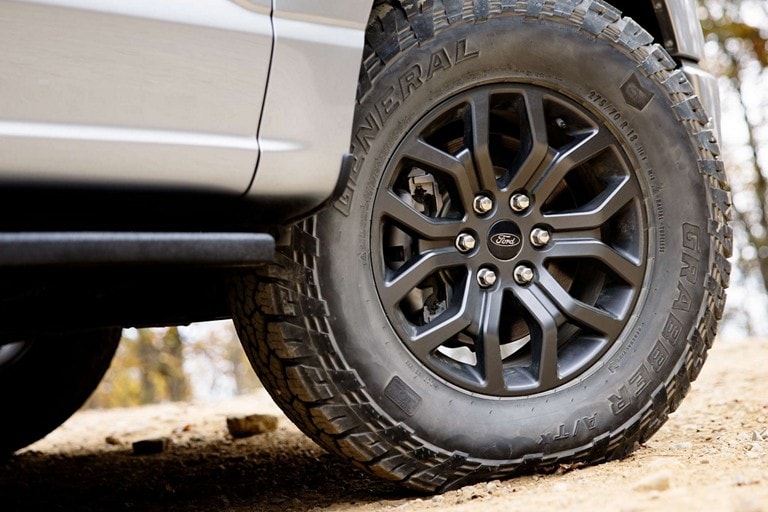 Close-up of 18-inch aluminum wheels in Dark Matte finish on a 2022 Ford F-150® Tremor®