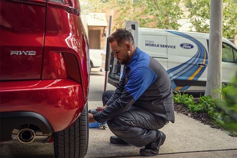 A Ford Mobile Service Technician works on a Ford vehicle.